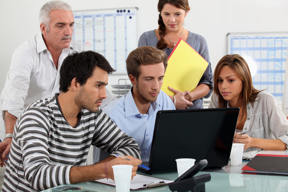 Office workers looking at computer Team looking at computer