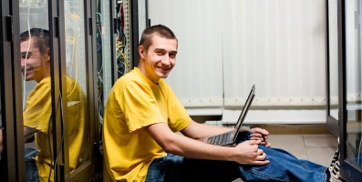 Profissional de TI sentado no data center