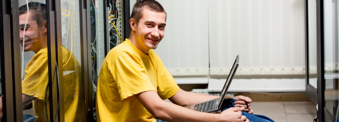 Profissional de TI sentado no data center