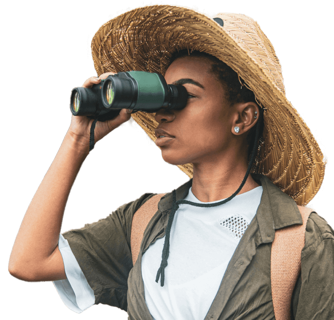 woman in an adventure hat looking through binoculars