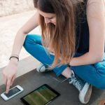 Visitor Stitching vs Vistior Linking - girl with mobile and tablet